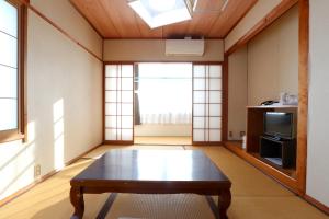 a living room with a table and a tv at Suikoen in Yonago