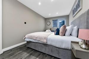 Un dormitorio con una cama grande y una ventana en City Paradise- 3 BDR Flat w/ Spacious Garden en Greenford