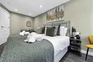 1 dormitorio con 1 cama grande con almohadas blancas en City Paradise- 3 BDR Flat w/ Spacious Garden en Greenford