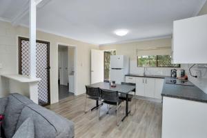 cocina y sala de estar con mesa y sillas en Gold Rush Apartments, en Gympie