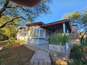una casa pequeña con porche y ventana en Raíces serranas, en Villa Las Rosas