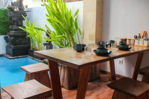 einen Holztisch mit Gläsern und Schalen darüber in der Unterkunft Chua Guest house Canggu in Canggu
