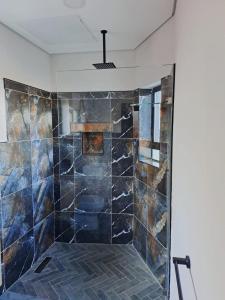 uma casa de banho com um chuveiro com azulejos azuis em 14 on Lawrence em Durban