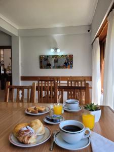 stół z talerzami jedzenia i kubkami kawy w obiekcie Hotel Portofino by CPH w mieście Villa Gesell