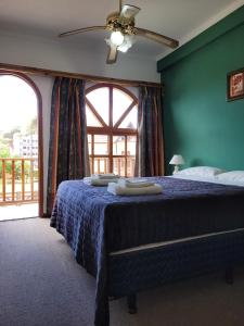 Un dormitorio con una cama con paredes azules y una ventana en Hotel Portofino by CPH en Villa Gesell