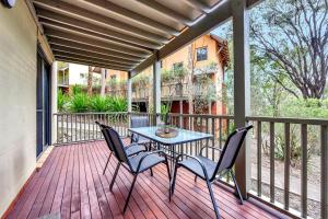 un patio con mesa y sillas en una terraza en Villa 1br Burgundy Villa located within Cypress Lakes Resort en Pokolbin