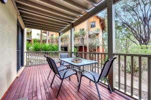 un patio con mesa y sillas en una terraza en Villa Spa Executive 1br Burgundy located within Cypress Lakes Resort en Pokolbin