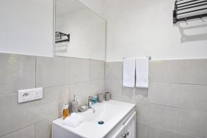 ein weißes Badezimmer mit einem Waschbecken und einem Spiegel in der Unterkunft Balconies at Grand Case in Grand Case