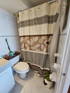 uma casa de banho com um WC e uma cortina de chuveiro em Habitación duerme y disfruta junto al mar em Iquique