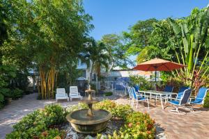 una fuente en un jardín con sillas y una sombrilla en Old Town Garden Villas - Andros Suite, en Key West