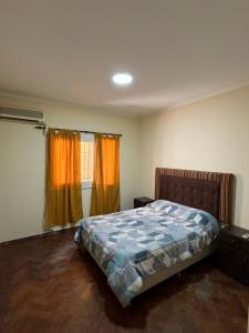 a bedroom with a bed and orange curtains at Av. España Microcentro in Mendoza