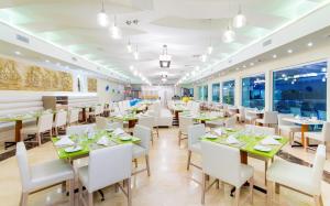 a restaurant with white tables and white chairs at Hotel Dann Cartagena in Cartagena de Indias