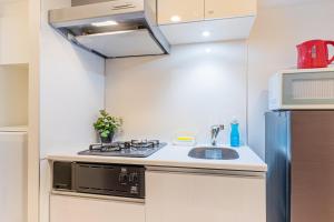 une cuisine avec une cuisinière et un évier dans l'établissement Brilliant MK- III, à Tokyo