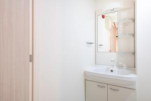une salle de bains blanche avec un lavabo et un miroir dans l'établissement Brilliant MK- III, à Tokyo 46 autres photos
