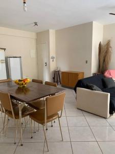 uma sala de estar com uma mesa e cadeiras e um sofá em Apartamento no Guarujá para 8 pessoas no Guarujá