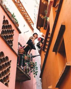 un uomo e una donna sul balcone di un palazzo di Hotel Casa Posos a Guanajuato