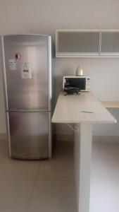 a kitchen with a stainless steel refrigerator and a counter at House Suites in Paragominas