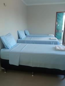 two beds sitting next to each other in a room at House Suites in Paragominas