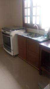 a kitchen with a stove and a sink at House Suites in Paragominas