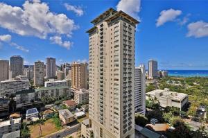 a tall building in front of a city at Brooks Beach Vacations 4 star Wyndham Resort 2003 Waikiki in Honolulu
