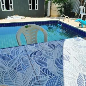 a swimming pool with a table and two chairs in it at Cantinho do sossego in Macaé