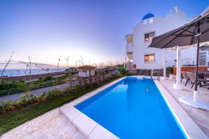 una piscina di fronte a una casa con l'oceano di Crystal Villa ikema a Miyakojima