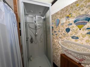 uma cabina de duche na casa de banho com uma cortina de chuveiro em ゲストハウス　アロマ em Ureshino