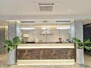 a man sitting at a counter in a hotel lobby at The 9 Residence Hotel in Bangkok