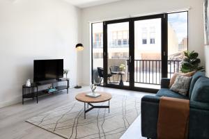 a living room with a couch and a tv at Urban Rest Port Adelaide Apartments in Port Adelaide