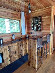 a kitchen with a bar in a tiny house at Recanto do Ipê cabana 01 in Urubici +17 photos