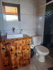 y baño con lavabo y aseo. en Recanto do Ipê cabana 01 en Urubici