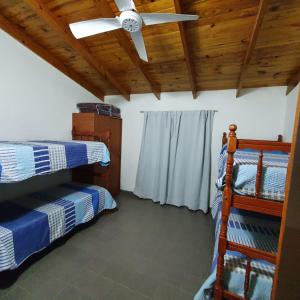 um quarto com 2 beliches e uma ventoinha de tecto em GUDIVAMA. em Las Grutas