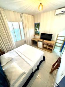 - une chambre avec un lit et une télévision à écran plat dans l'établissement Coral azul Noronha, à Fernando de Noronha