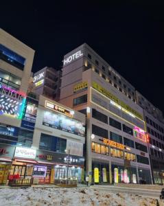 un edificio con muchas señales en él por la noche en Gimpo JK Hotel en Gimpo