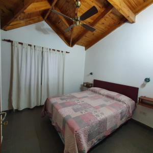 a bedroom with a bed and a ceiling fan at GUDIVAMA. in Las Grutas