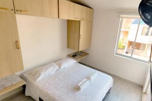 1 dormitorio con cama blanca y ventana en Casa de Encanto Vacacional con piscina en Anapoima, condominio privado hasta 9 personas en Anapoima
