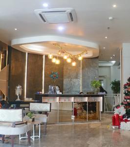 un vestíbulo con un restaurante con un árbol de Navidad en él en We Hotel Lubuklinggau, en Lubuklinggau