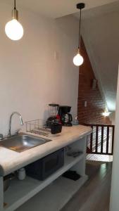 Una encimera de cocina con un fregadero y dos luces. en Loft guelaguetza A, en Santa Cruz Huatulco 9 fotos más