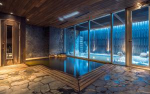 a swimming pool in a room with a large window at The Vale Niseko in Kutchan