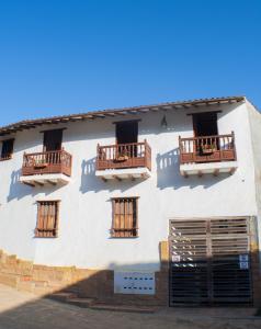 a white building with two balconies and two doors at El Retiro Barichara 206 in Barichara