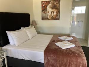 een slaapkamer met een bed met een standbeeld van een hoofd bij Porky's Motel Rockhampton in Rockhampton