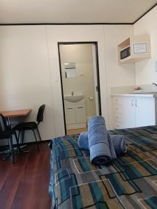 Un dormitorio con una cama con toallas azules. en Mt Isa Caravan Park, en Mount Isa