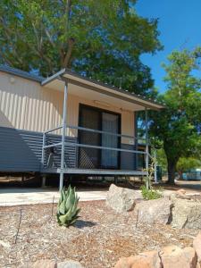 a house with a cactus in front of it at Mt Isa Caravan Park in Mount Isa