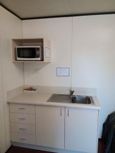 a kitchen with a sink and a microwave at Mt Isa Caravan Park in Mount Isa