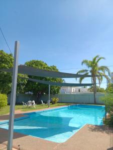 a blue swimming pool with a pergola at Mt Isa Caravan Park in Mount Isa