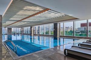 een groot zwembad in een gebouw met ramen bij Doubletree By Hilton Shenzhen Airport Residences in Shenzhen