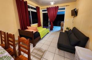 ein Wohnzimmer mit einem Sofa und ein Wohnzimmer mit einem TV in der Unterkunft Fare Moana Bord de Mer Fare Tepua Lodge in Uturoa