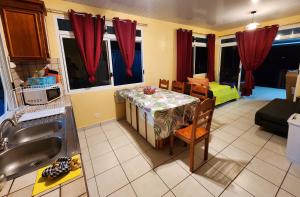 Il comprend une cuisine avec une table et un canapé. dans l'établissement Fare Moana Bord de Mer Fare Tepua Lodge, à Uturoa