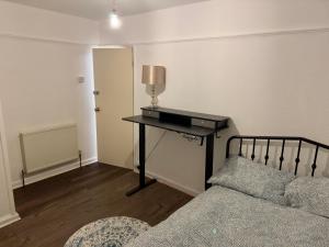 een slaapkamer met een bed en een bureau met een lamp bij Warm Home in Birmingham's Peaceful Green Oasis in Frankley