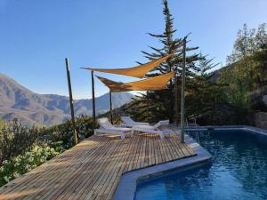 a swimming pool with two chairs and a umbrella at Refugio cordillerano, quincho y piscina in San Francisco